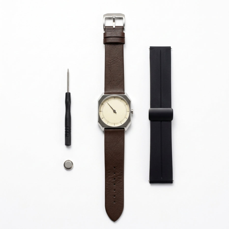 Relógio Rettrato 38mm Creme Fabbricantti com pulseira marrom, acompanhado de pulseira preta extra, ferramenta e bateria, sobre fundo branco.